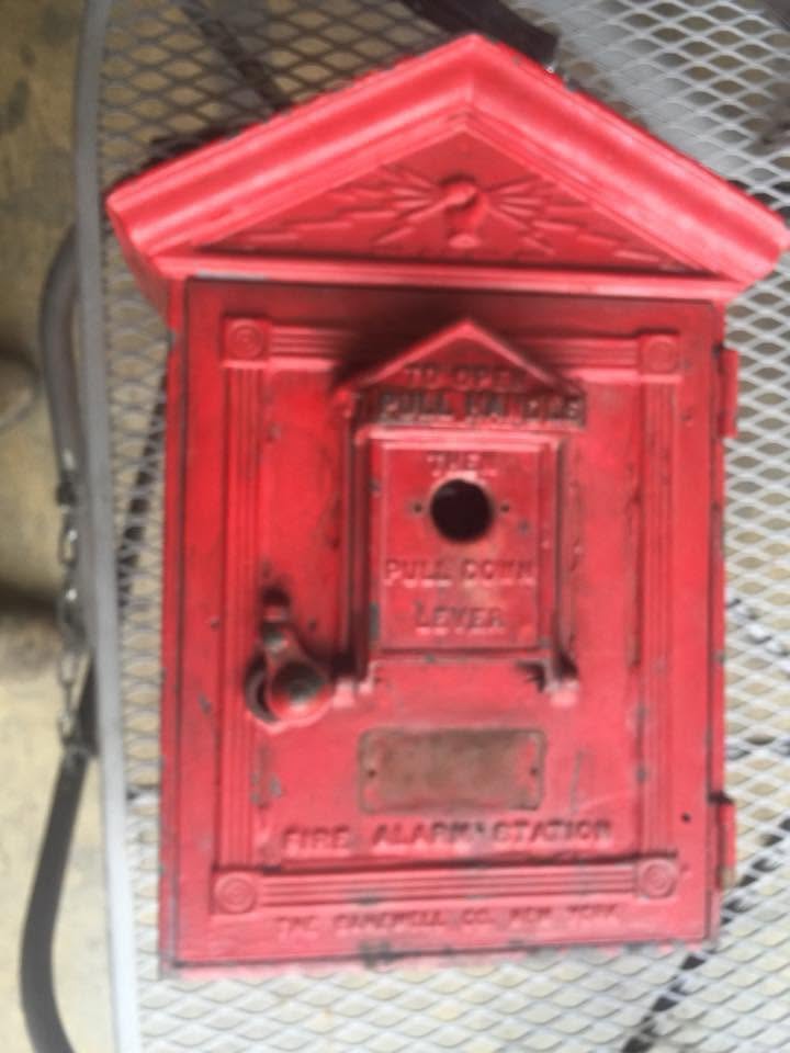 Antique cast-iron fire alarm box before restoration, faded and worn